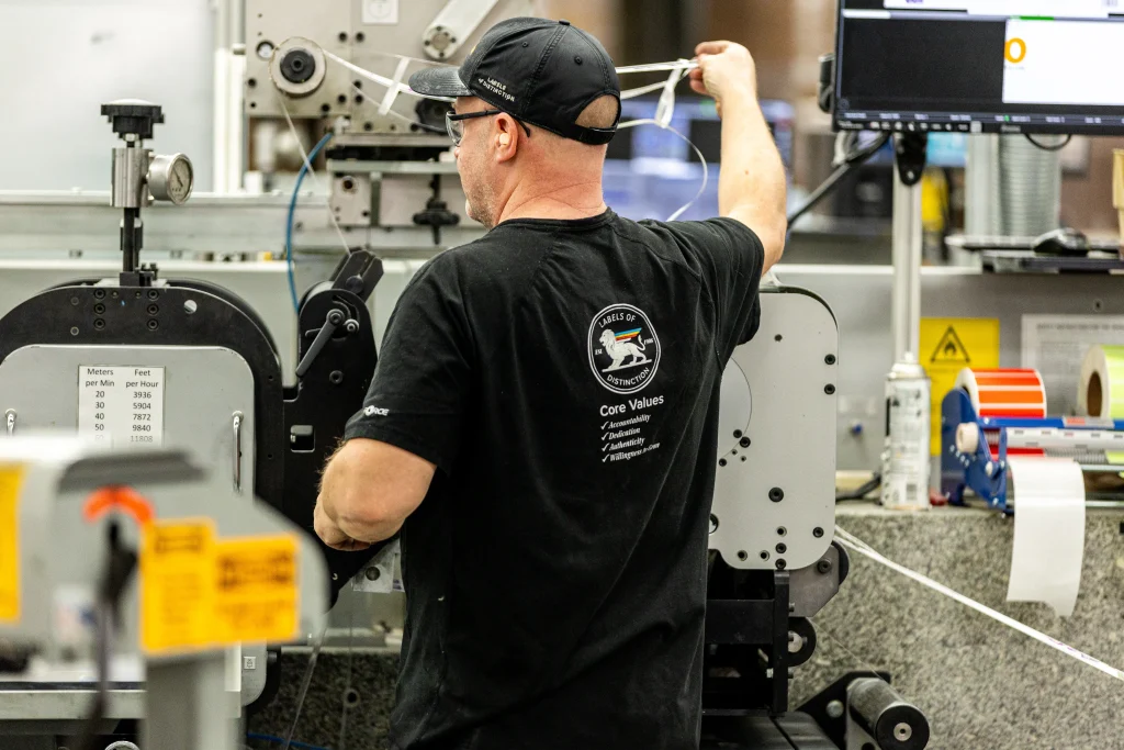 A quality control employee ensures smooth label surfaces for the best possible label adhesive strength.