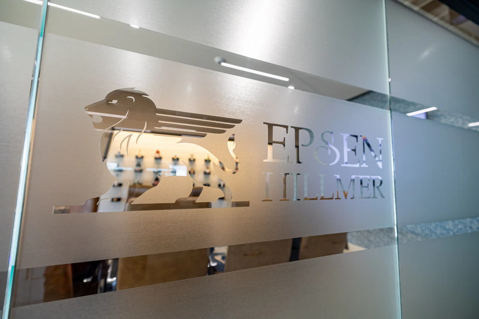 The Epsen Hillmer Graphics logo is seen on varnished glass